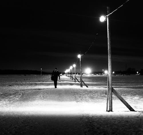 Free Black-and-White Photography of a Person Walking on Snow-Covered Ground Stock Photo