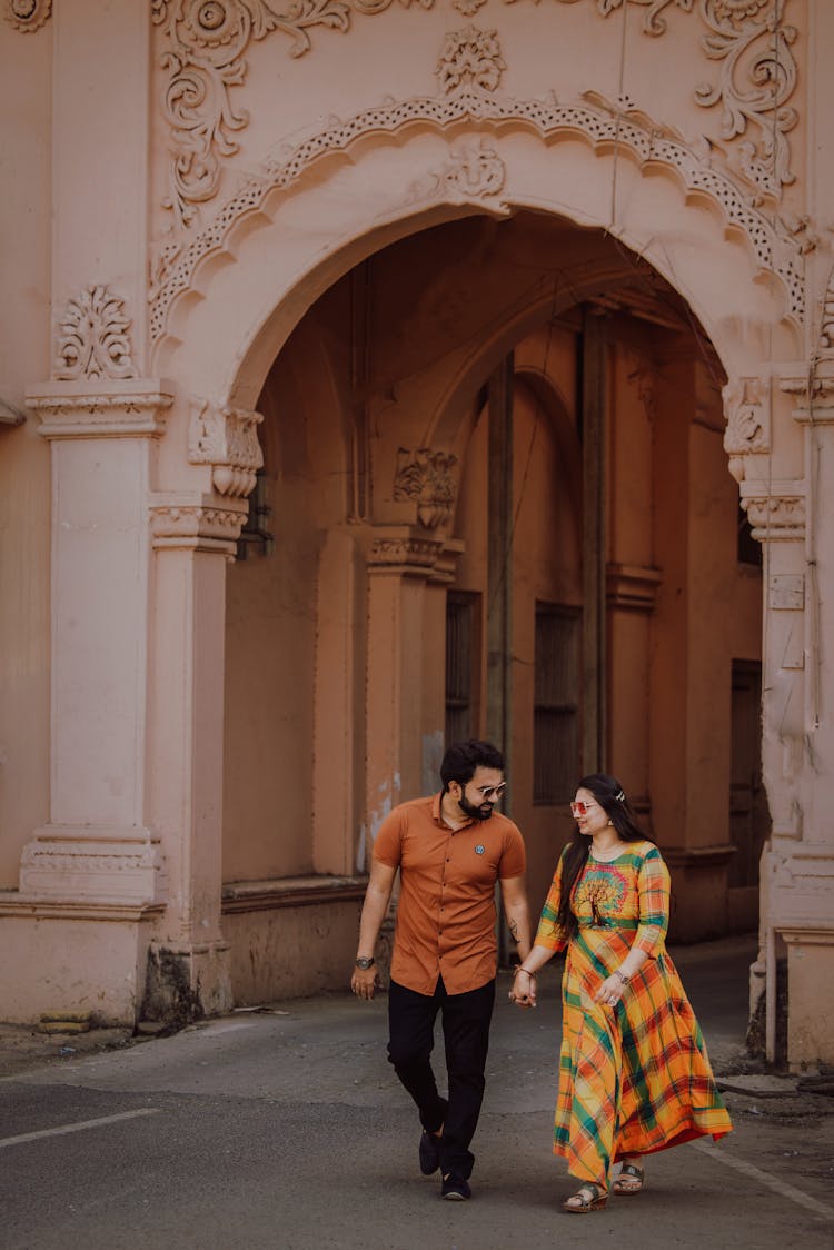 Couple Walking Together Near Building Arch