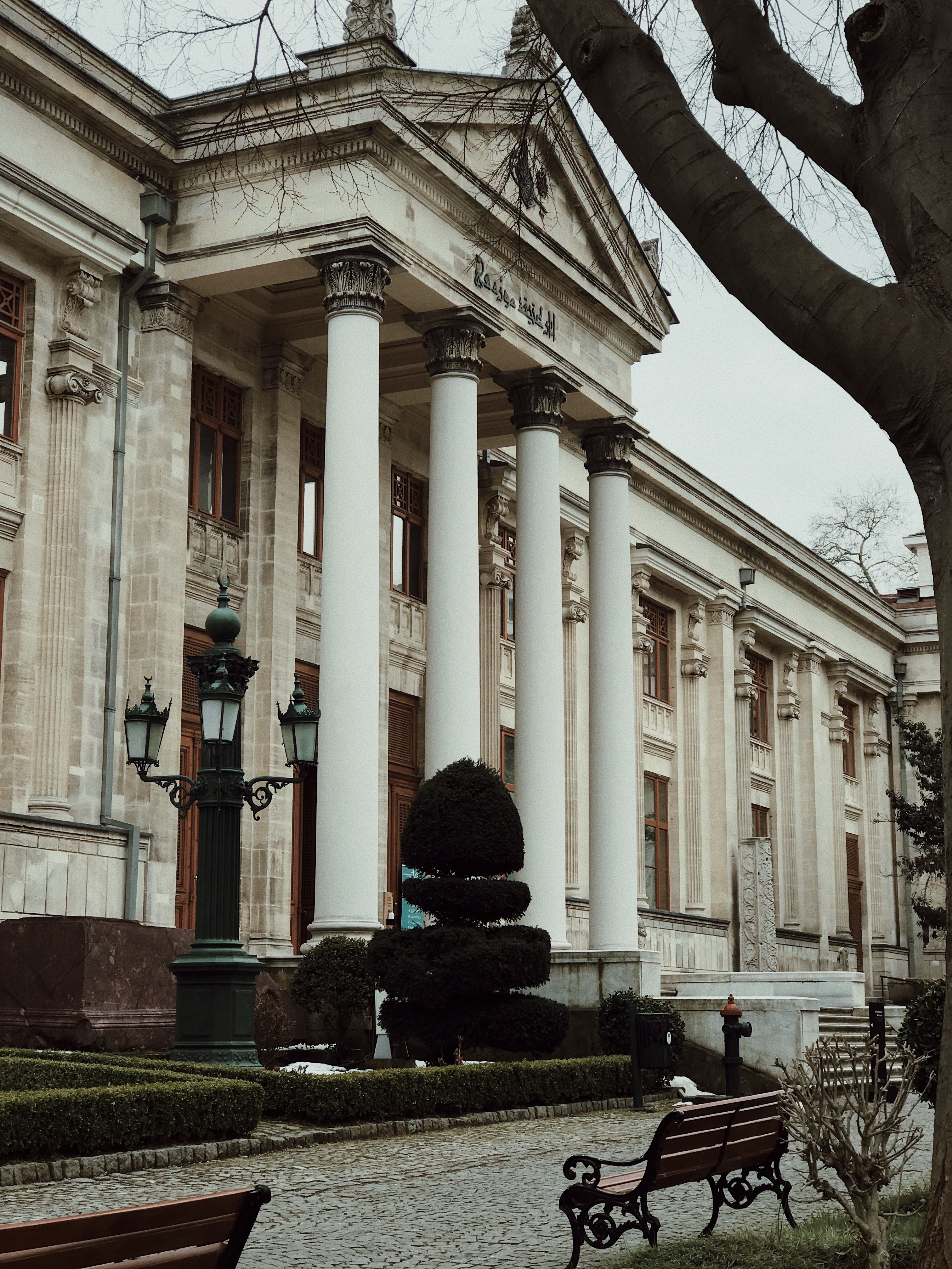 A neoclassical museum facade with columns in Istanbul, featuring a serene garden setting.