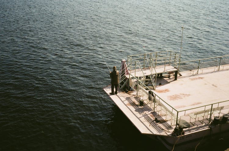 Man On Pier Fishing In Sea