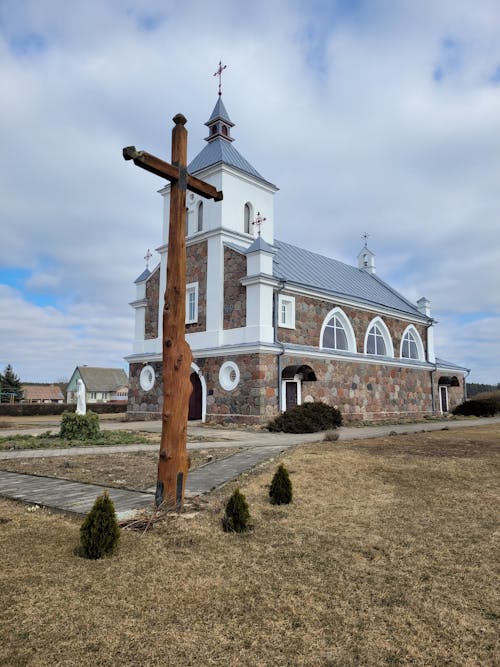 Brown and White Stone Church Under Blue Cloudy Sky