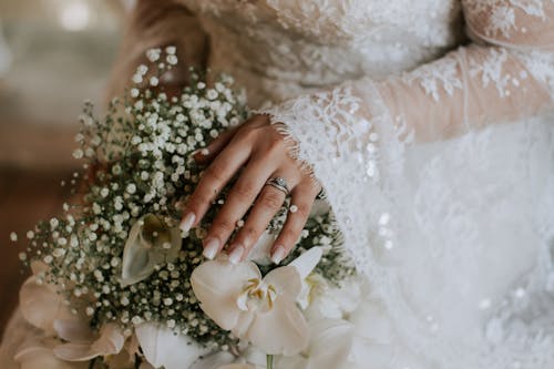 Woman in White Wedding Gown Holding Bouquet of Flowers 