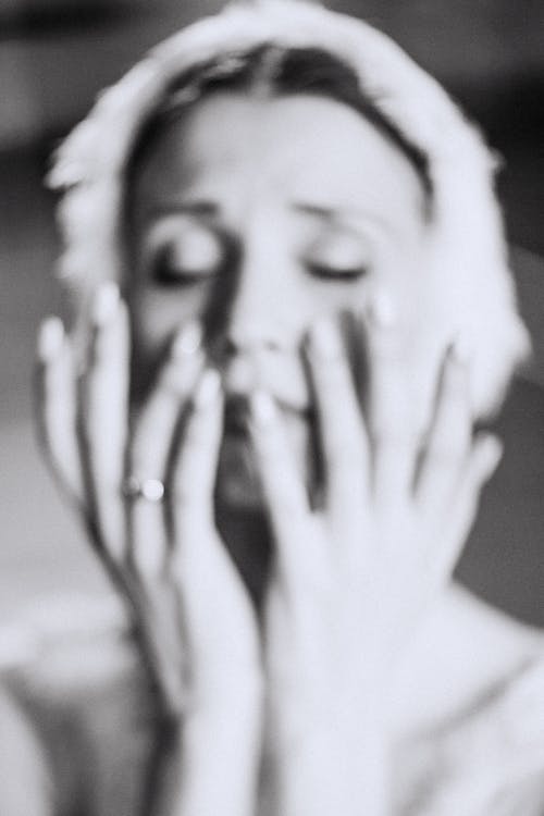 Grayscale Photo of Woman Touching Her Face 