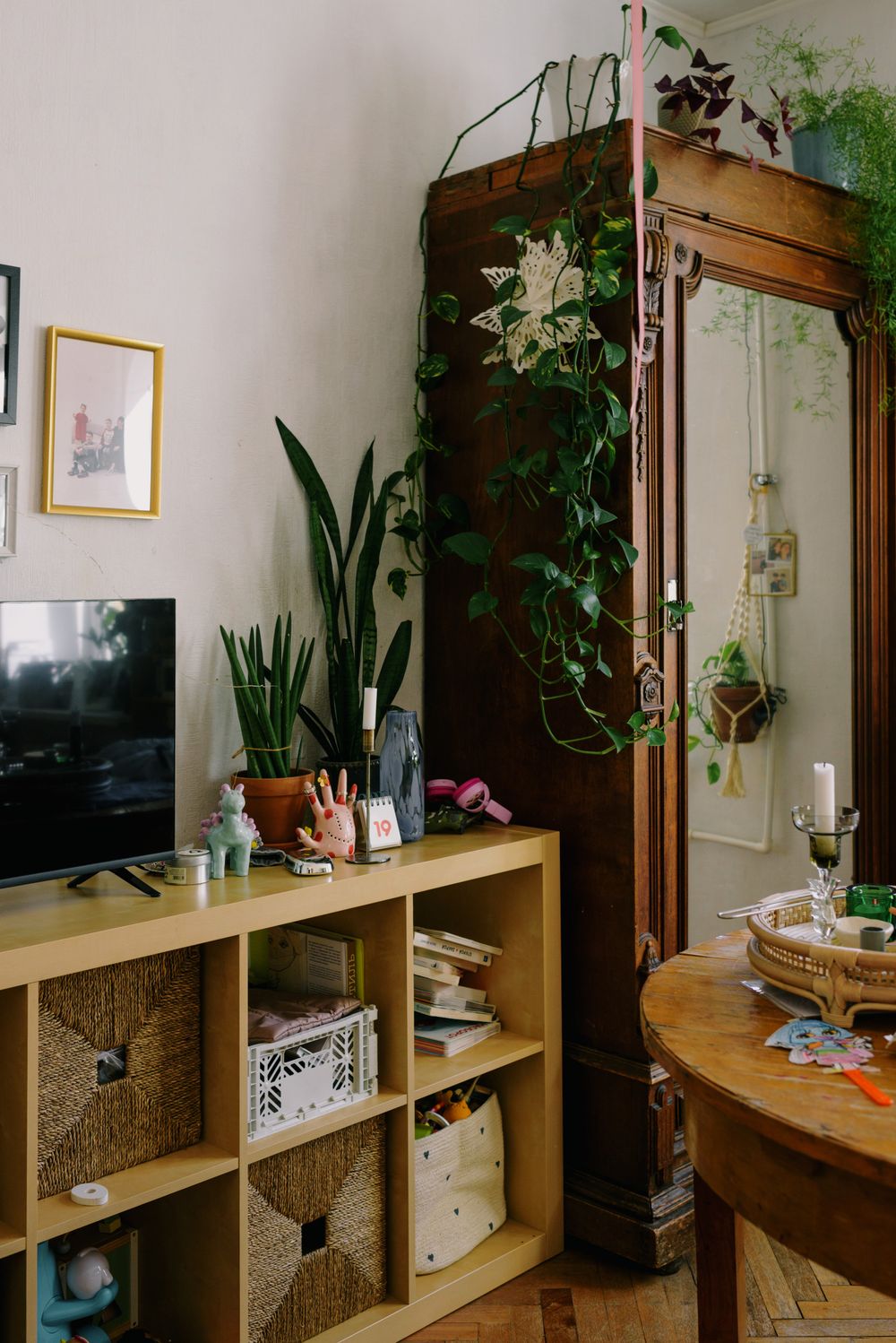 Warm living room corner with wooden shelving, plants and woven storage baskets