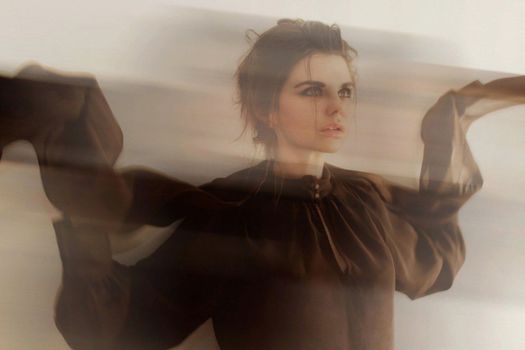 Dramatic portrait of a woman in motion with a blurred effect, creating an expressive artistic look.