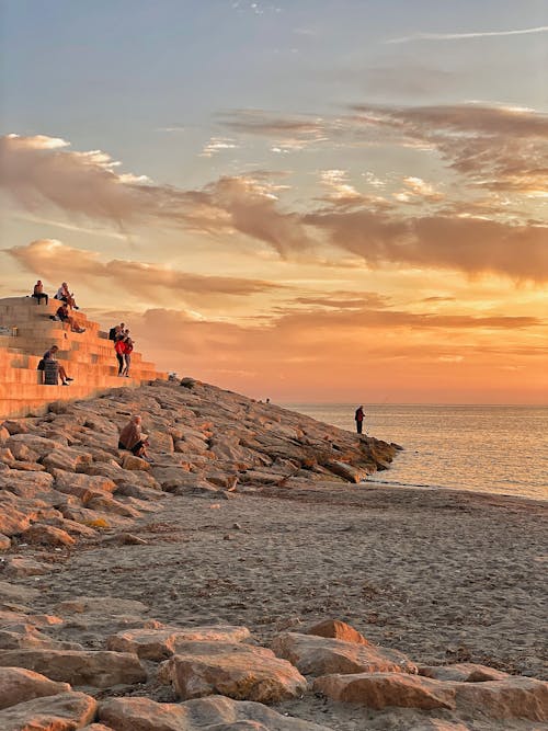 Free People fishing by the Seaside during Dusk  Stock Photo