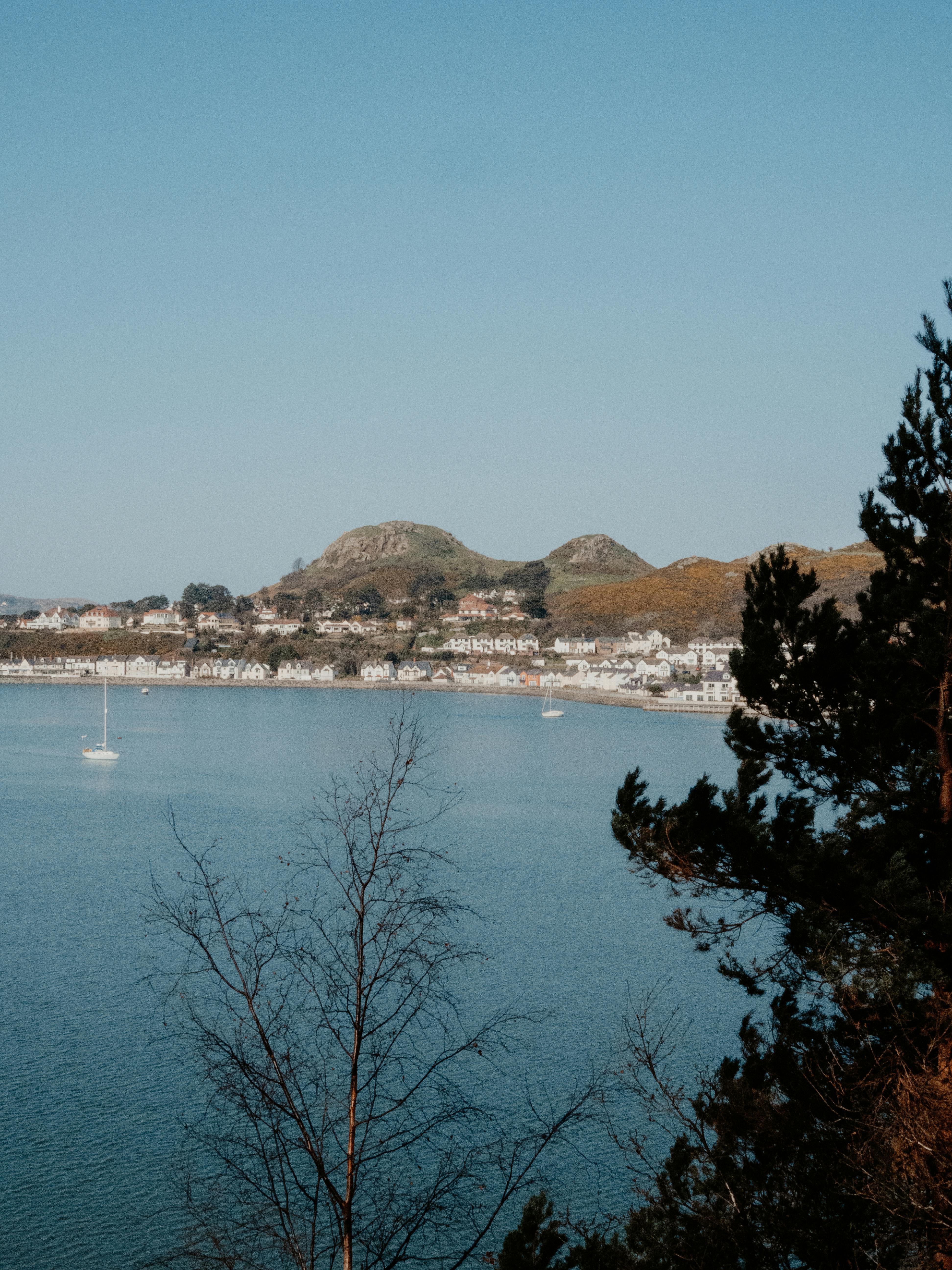 A picturesque coastal town near mountains and sea, with boats and nature.