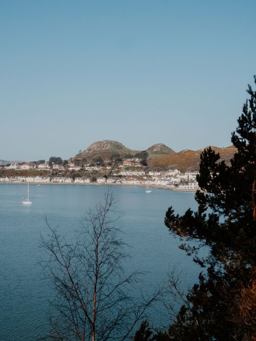 Free A picturesque coastal town near mountains and sea, with boats and nature. Stock Photo