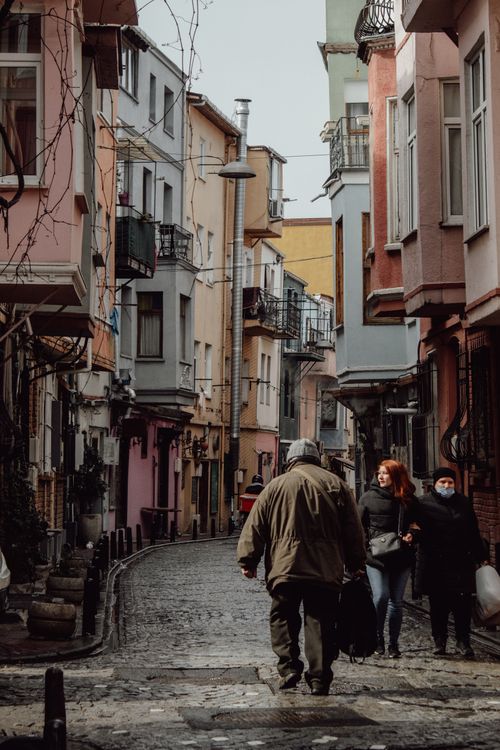 Free Strolling through a colorful alleyway in Istanbul's historic district with people walking and enjoying the cityscape. Stock Photo