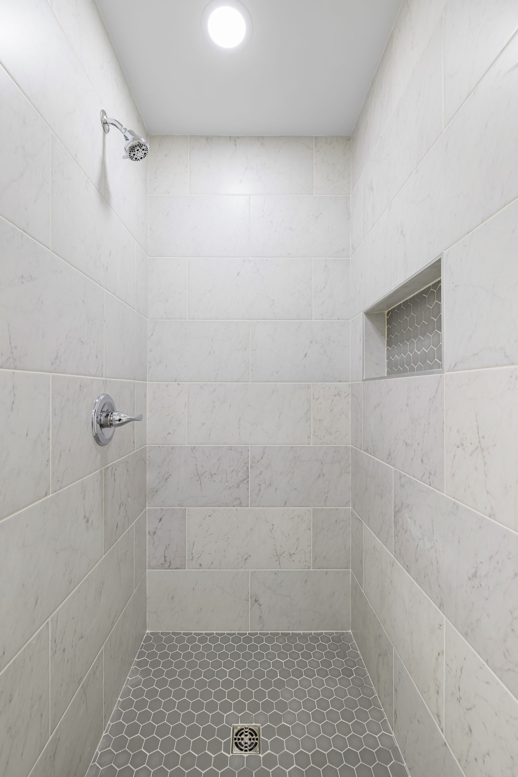 Minimal shower with grey tiles and contemporary showerhead