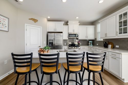 Free Bright modern kitchen interior featuring sleek design, bar seating, and stainless steel appliances. Stock Photo