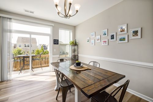 Free A spacious dining area with a wooden table and modern decor, bathed in natural light. Stock Photo