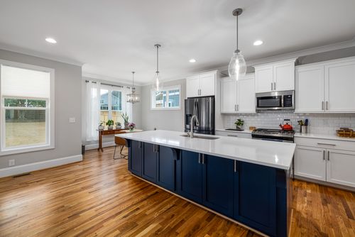 Free Spacious kitchen featuring white cabinetry and wooden flooring, perfect for modern homes. Stock Photo