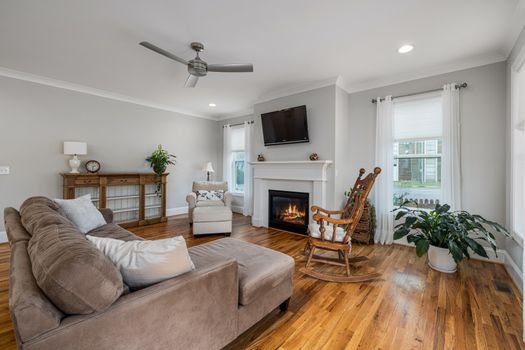 Spacious, modern living room with fireplace, wooden floors, and elegant furniture.