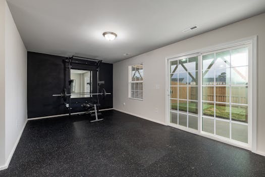 Spacious home gym featuring weightlifting equipment and a mirrored wall.