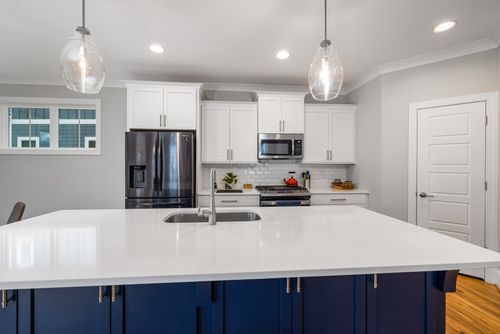 Free Stylish modern kitchen with a spacious white countertop and stainless steel appliances. Stock Photo