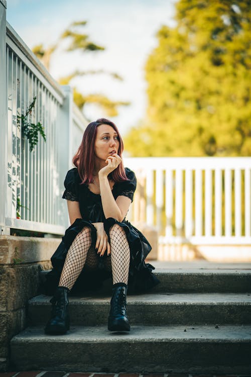 Woman in Black Dress Sitting on Stairs