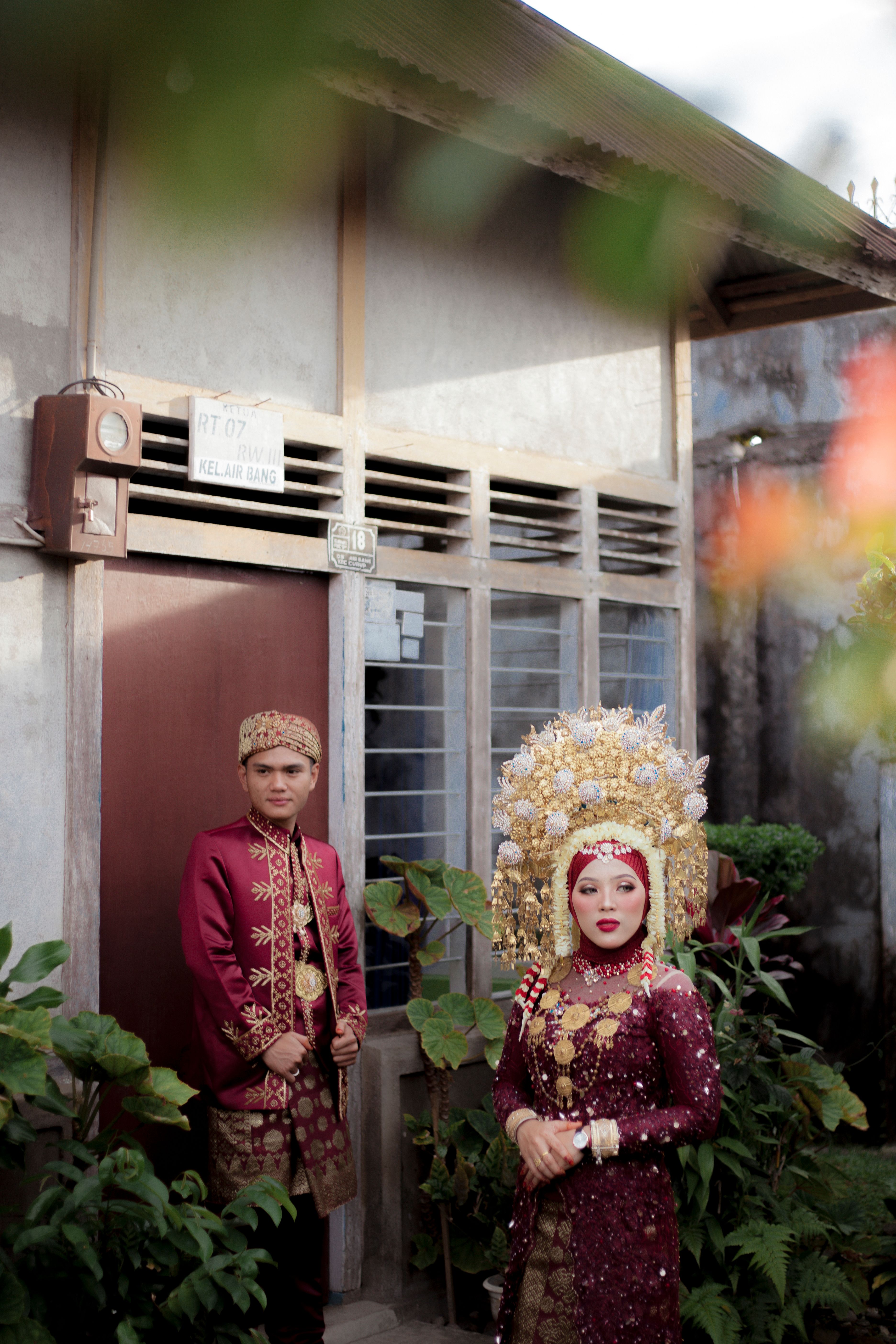 Elegant Indonesian couple in traditional wedding attire outdoors, showcasing cultural heritage.