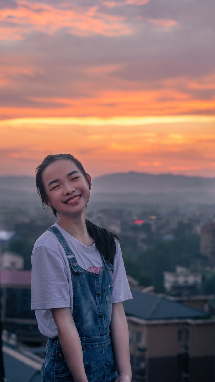 A Teenage Girl Smiling During Sunset