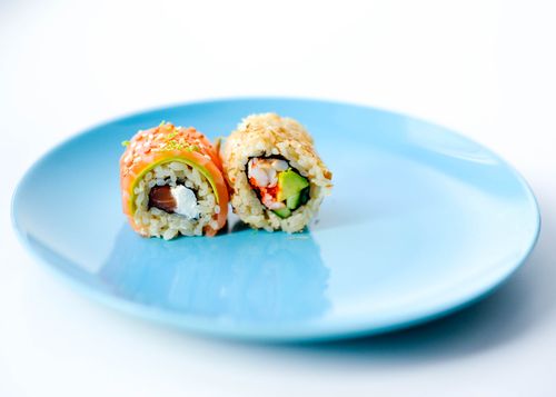 Free Close-up of two sushi rolls with fresh ingredients on a blue plate. Stock Photo