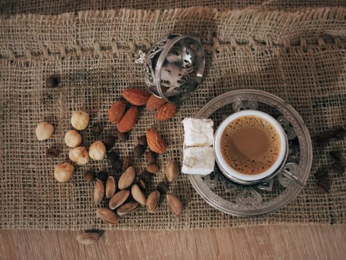 Free Overhead view of coffee with assorted nuts and Turkish delight on burlap. Stock Photo