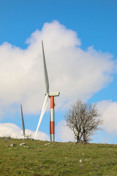 White and Red Turbine on Green Grass Field