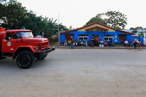 Red Truck near People sitting in Front of an Office