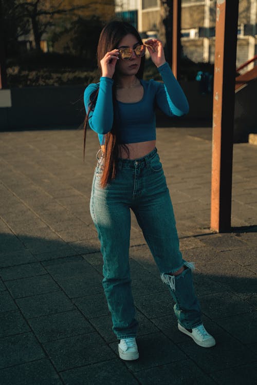 Free A Young Woman in a Trendy Outfit and Sunglasses Stock Photo