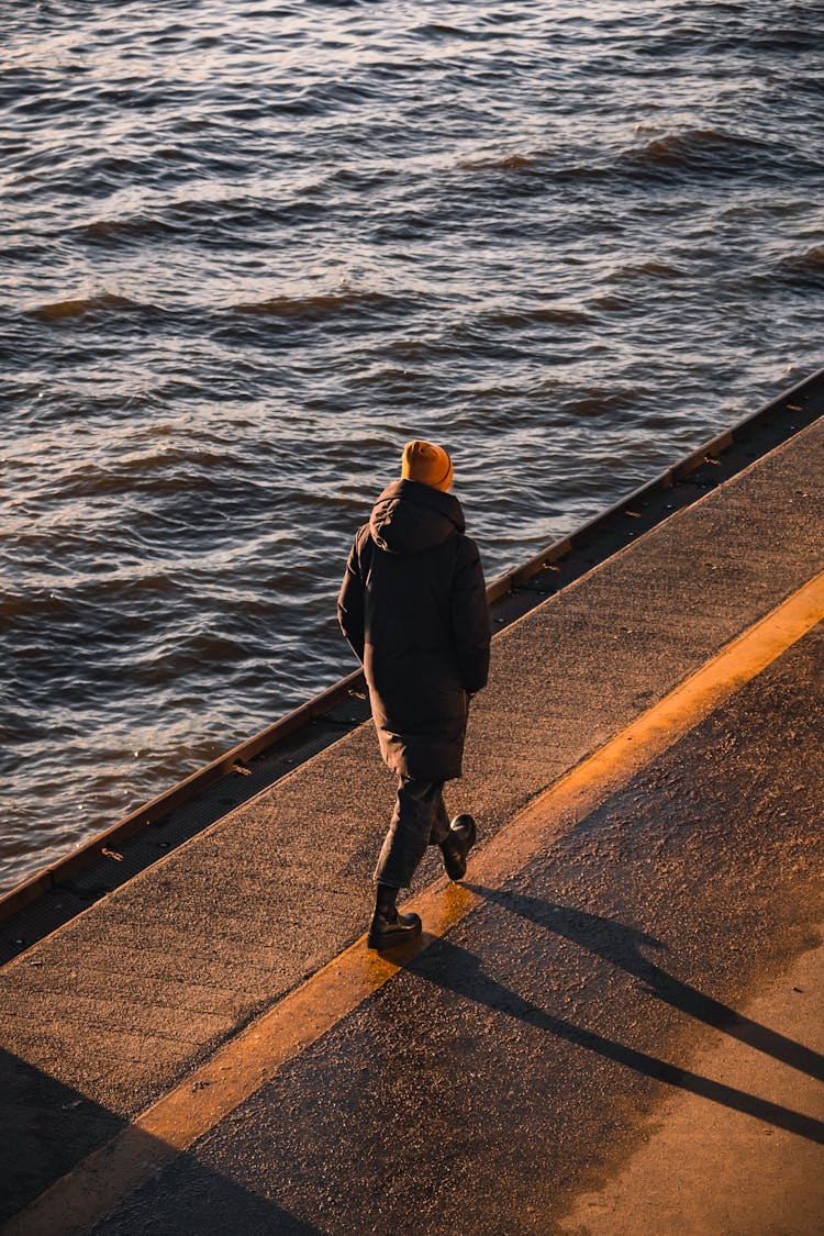 A Person Walking On The Seawall