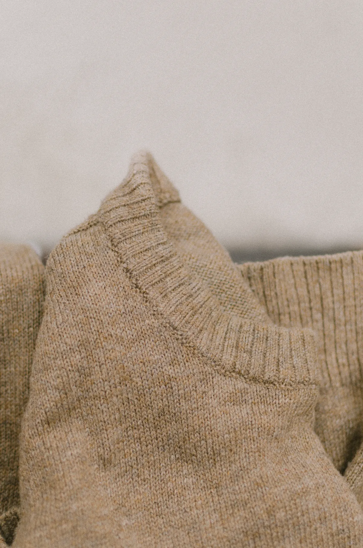 Tekstur sweater rajut cashmere wool warna beige natural premium untuk quiet luxury fashion