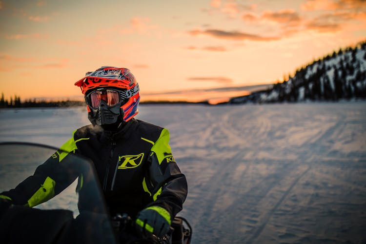 Riding Snow Scooter At Sunset