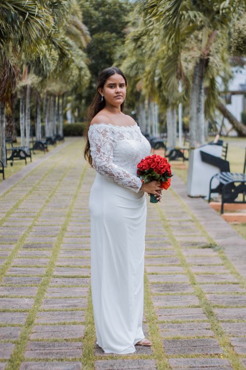 A Woman in White Dress Holding Bouquet of Red Roses · Free Stock Photo