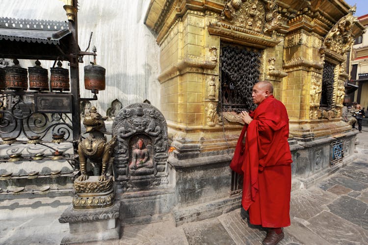 Monk Next To Buddha Figurine