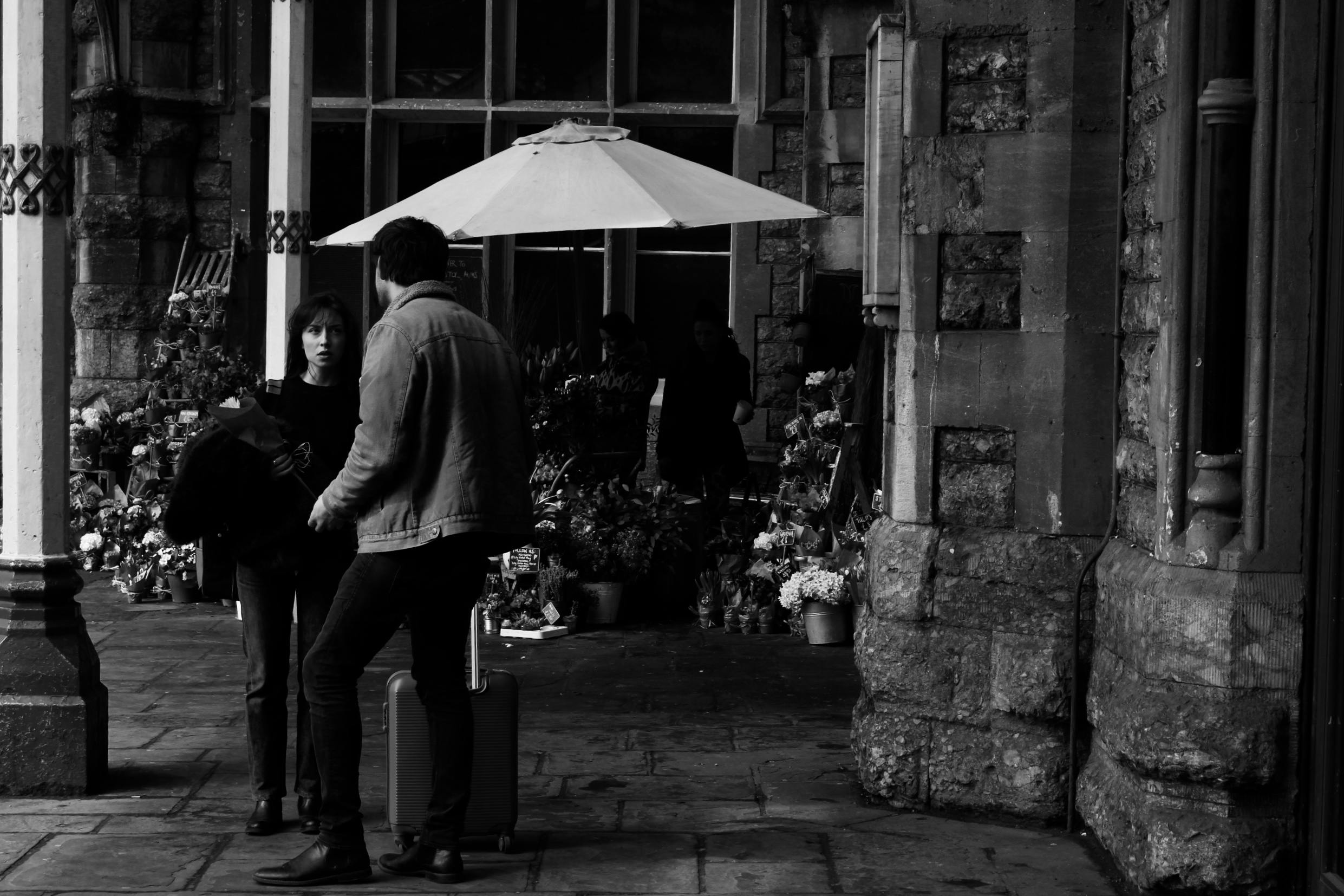 grayscale photography of man standing beside woman