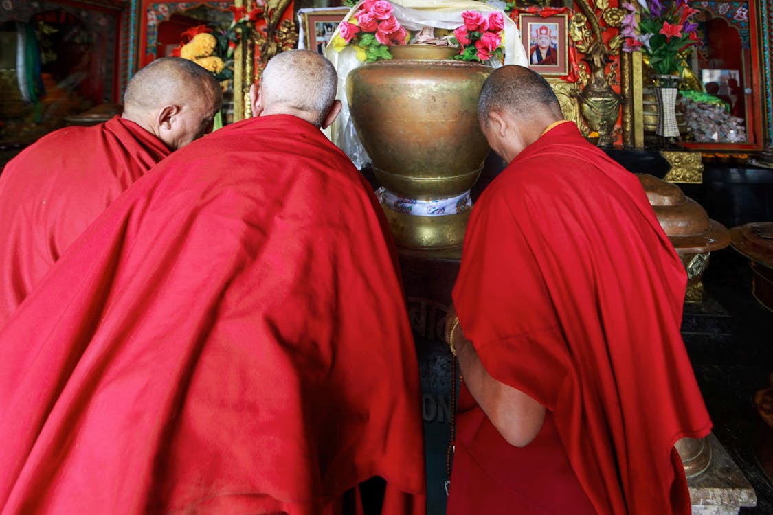 Monks in red Robe standing in front of an Altar