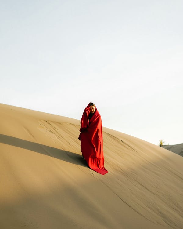 Woman in Red Robe standing on Desert 