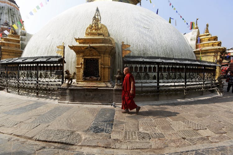 Monk In Robes Walking Near Temple