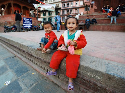 Innocent Kids sitting on Pavement 