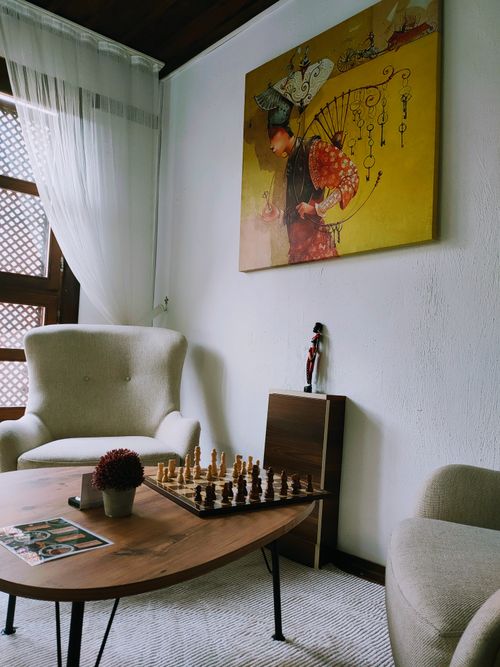 Free Stylish living room featuring a chess board and contemporary art piece. Stock Photo