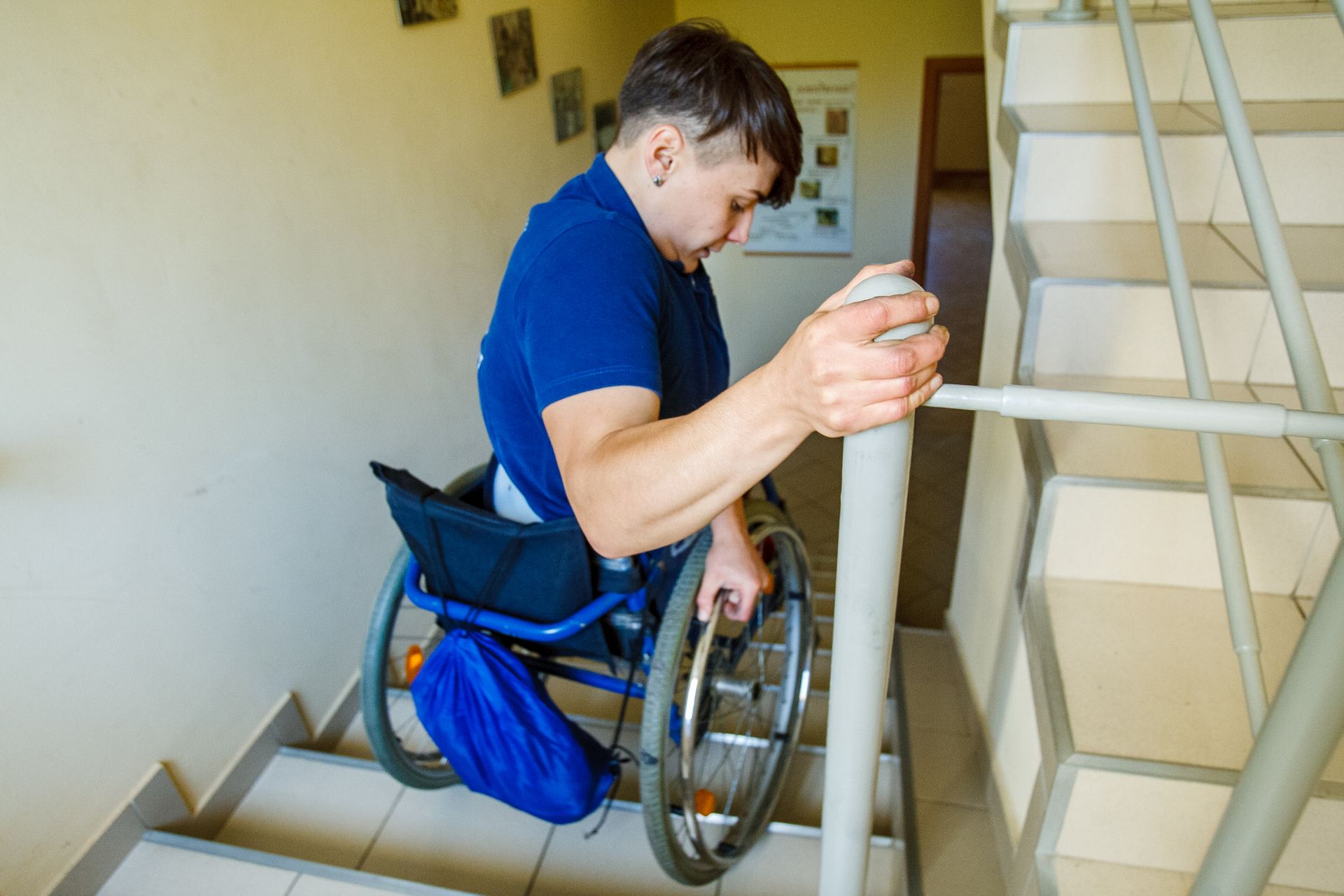 Man Sitting on a Wheelchair assisting himself on the Stairs