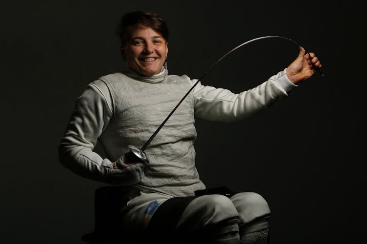 Woman Posing In Fencing Lame And With Sabre