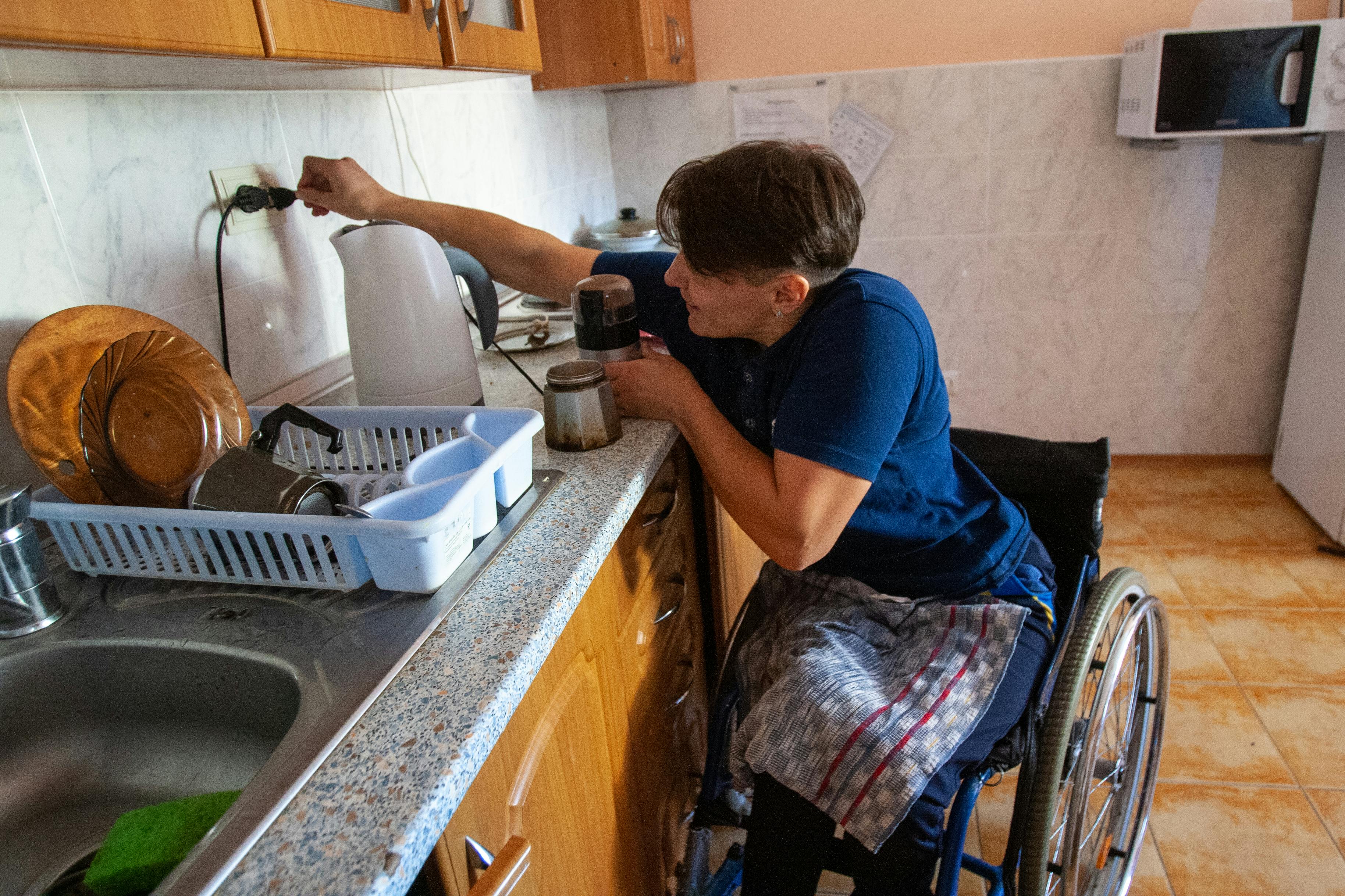 Woman on Wheelchair in Kitchen by Nadiia Doloh