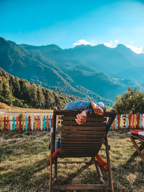 Person Lying on a Lounge Chair in Mountains