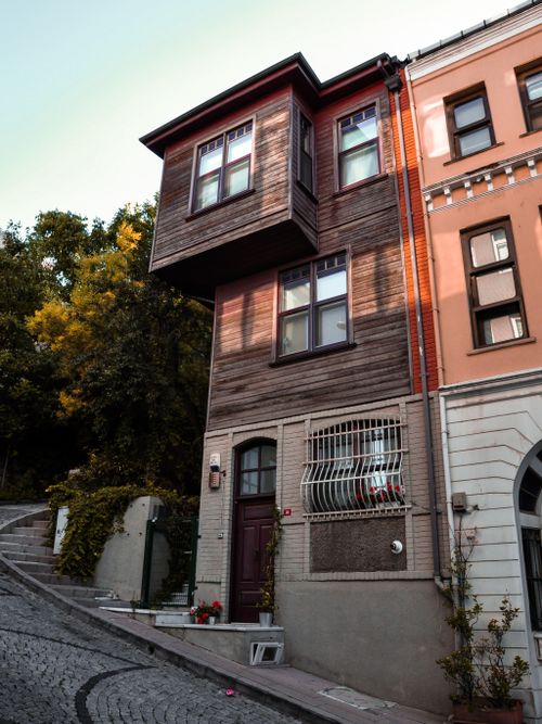Free Unique wooden facade house on a steep cobblestone street in a residential neighborhood. Stock Photo