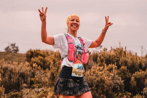 Free Smiling female athlete on a nature trail, celebrating with peace signs. Stock Photo