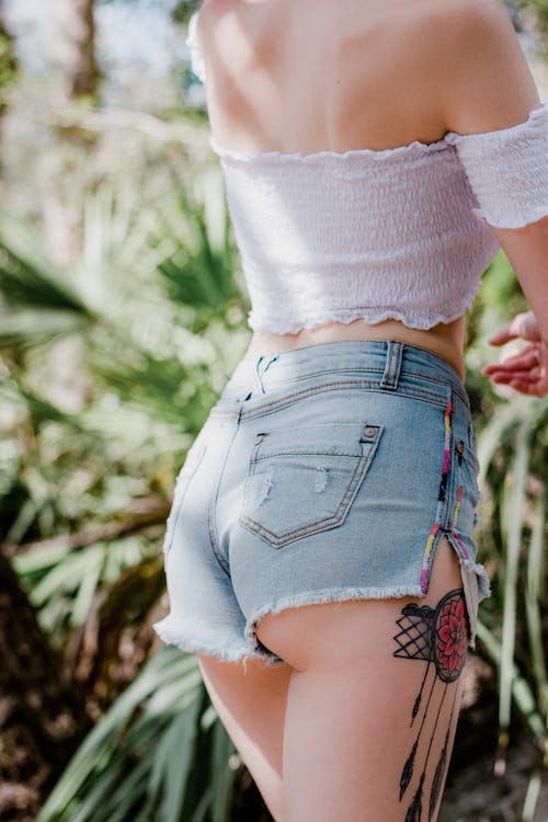 Close-Up Shot of a Woman Wearing White Tube Top and Blue Denim Shorts
