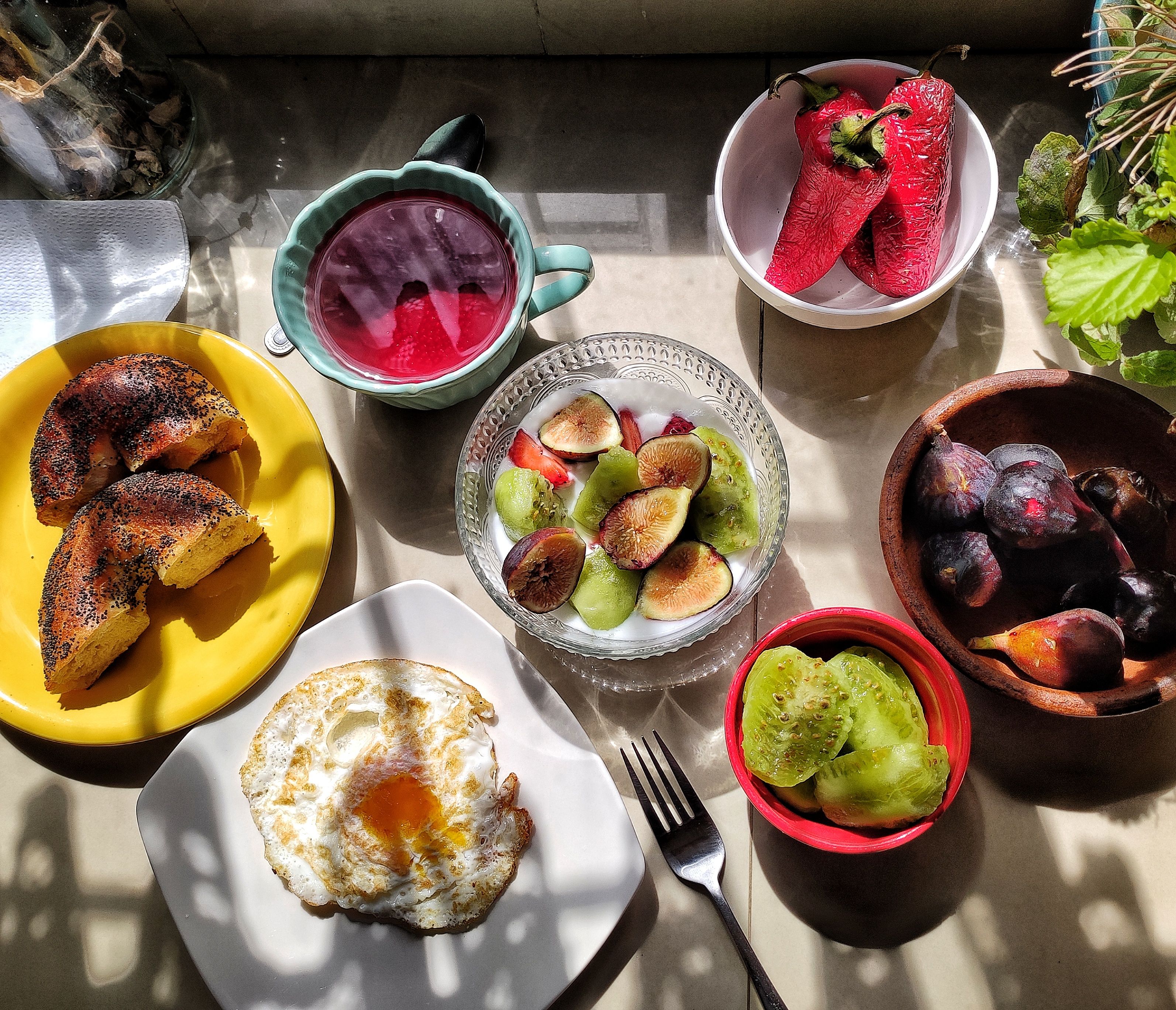 Bright and healthy breakfast with fruits, bagel, and egg, beautifully arranged.