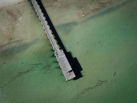 Stunning aerial shot of the Largs Bay pier extending into turquoise ocean waters.