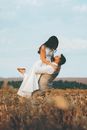 Man Picking Up Bride in Field