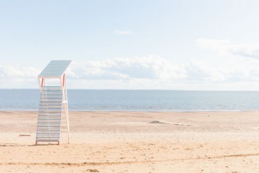 A serene and minimalistic beach scene featuring a lifeguard tower by the calm ocean.